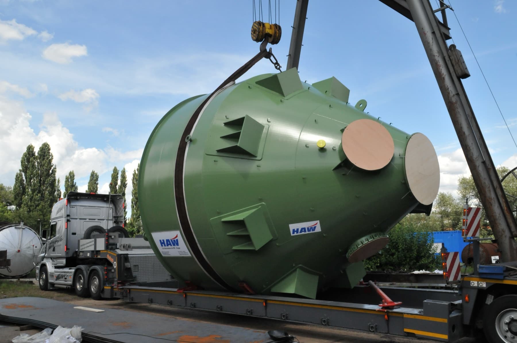 Ein von HAW gebauter Behälter wird im Werk auf einen Schwerlasttransporter gehoben